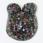 Ein Babybauch-Abdruck aus Gips von Brust und Bauch einer Schwangeren, gestaltet mit Mosaiksteinen gestaltet.