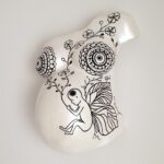 Ein Abdruck eines Babybauches aus Gips von Brust und Bauch, gestaltet mit floralen Mustern und einem Kind in der Darstellung eines Schmetterlings.