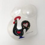 Ein 3D-Gipsabdruck eines Babybauchs von Brust und Bauch, bemalt mit einem Hahn und beschriftet mit dem Namen des Kindes.